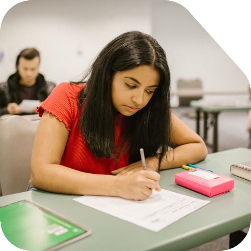 Students in an exam hall, writing her paper